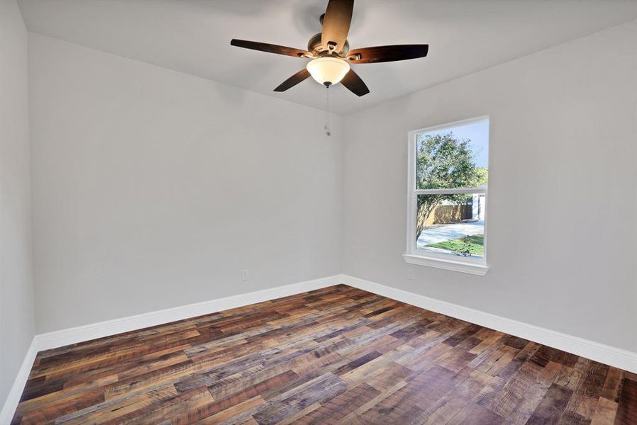 Unfurnished room with dark hardwood / wood-style floors and ceiling fan