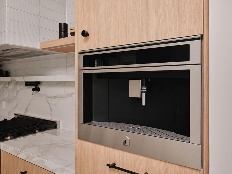 Integrated stainless steel appliance in wood-finish cabinetry