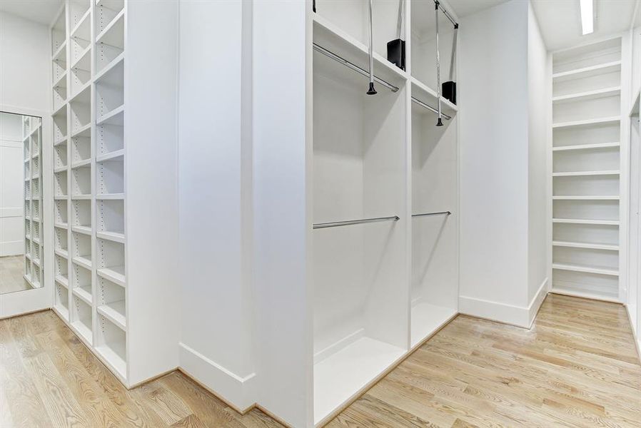 Huge custom master closet with shelves and pull down poles for an abundance of storage.