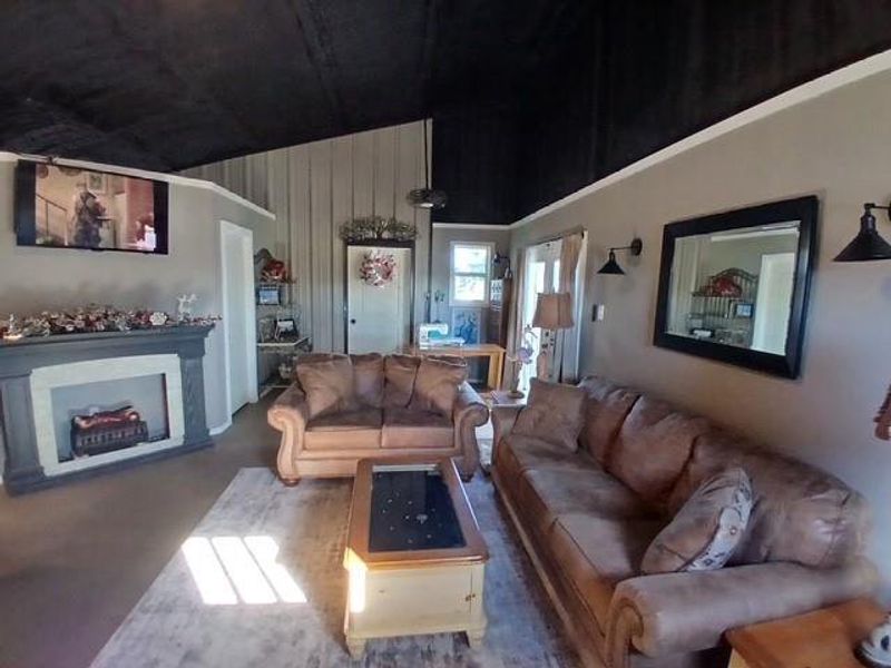 Living room with a fireplace and vaulted ceiling