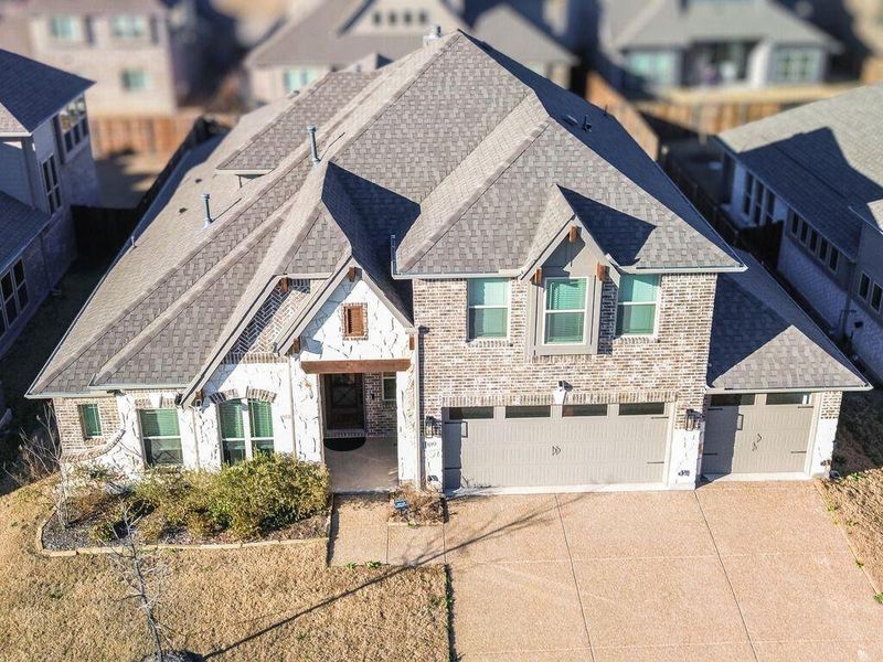 Drone View of front of home featuring roof with shingles, an attached garage, driveway, and a residential view Drone View of front of home featuring roof with shingles, an attached garage, driveway, and a residential view