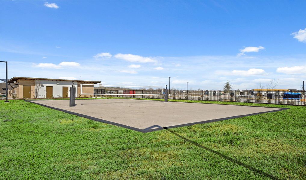 Outdoor volleyball court with a scenic backdrop.