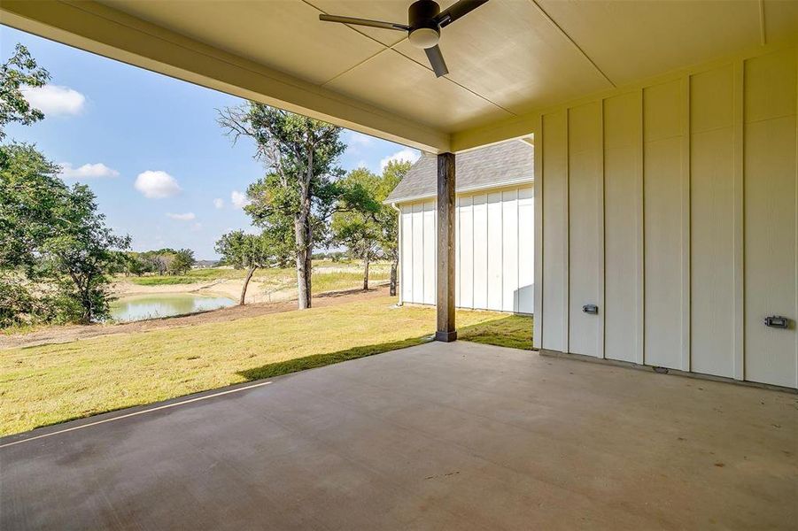 View of patio featuring a water view and ceiling fan