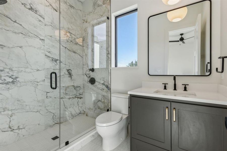 Bathroom with tile patterned floors, vanity, a shower with door, ceiling fan, and toilet