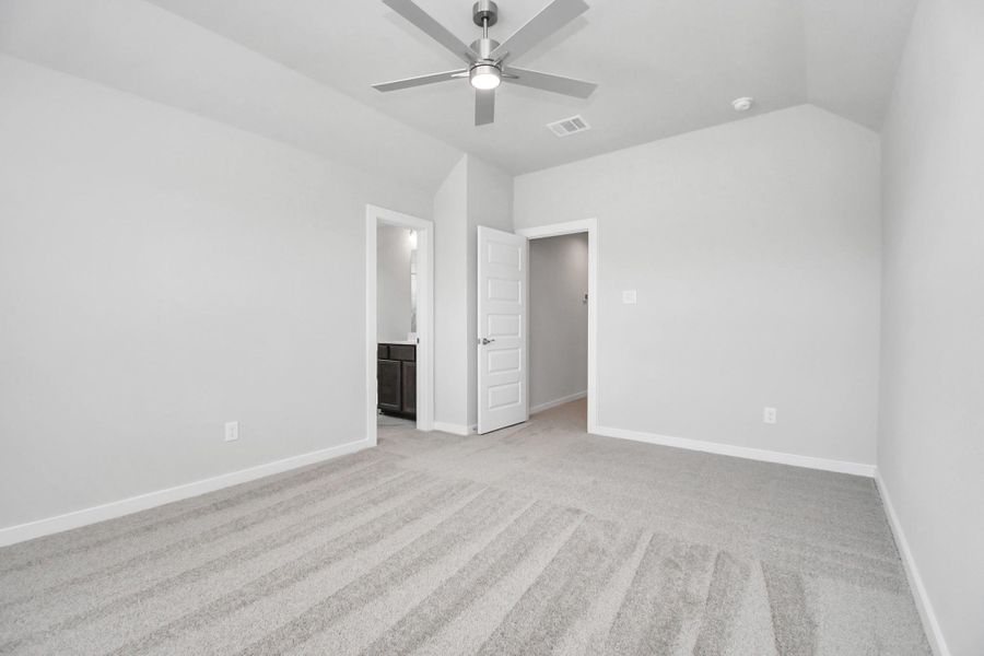 Inviting guest suite adorned with modern charm. The room features elegant 5-panel doors with sleek, contemporary hardware that adds a touch of sophistication. Sink your feet into the plush, fluffy carpet that invites comfort and warmth. Large windows flood the space with an abundance of natural light, framed by privacy blinds that offer the perfect balance between openness and seclusion. Sample photo of completed home with similar floor plan. Actual colors and selections may vary.