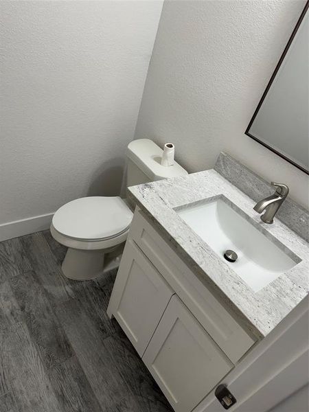 Bathroom featuring vanity, wood-type flooring, and toilet