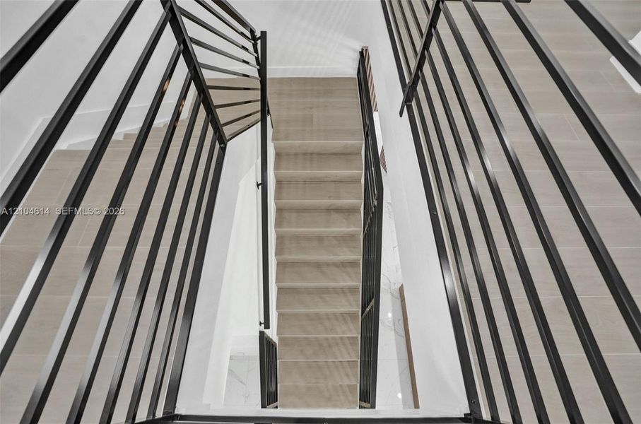 Multi-level staircase with contemporary black metal railings