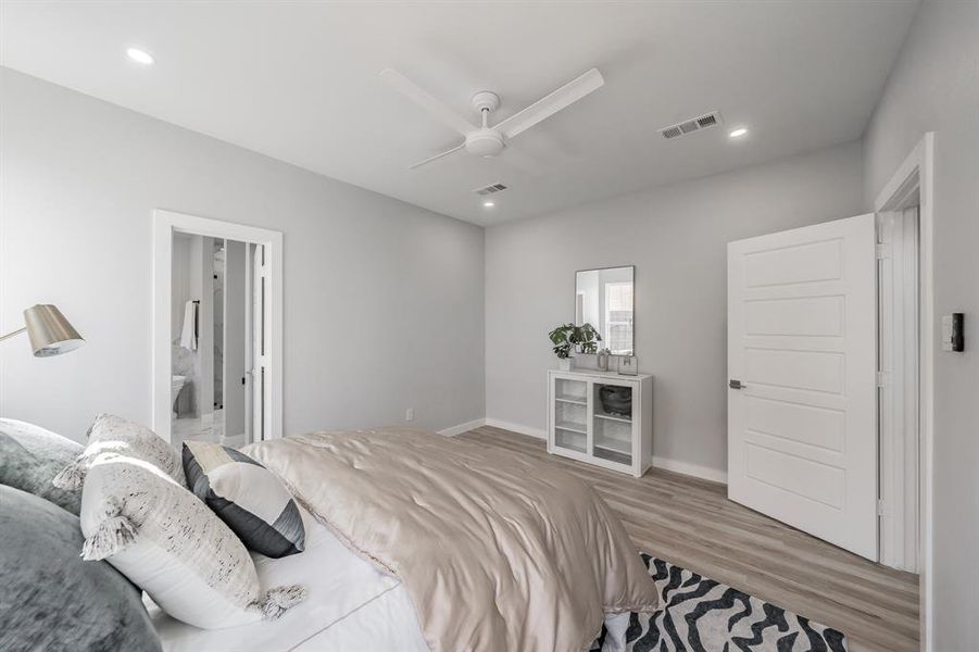 Bedroom featuring hardwood / wood-style flooring, ceiling fan, and ensuite bath