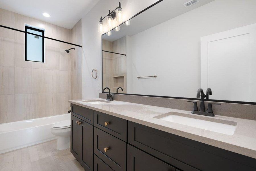 Bathroom with double vanity,  shower combination, and recessed lighting