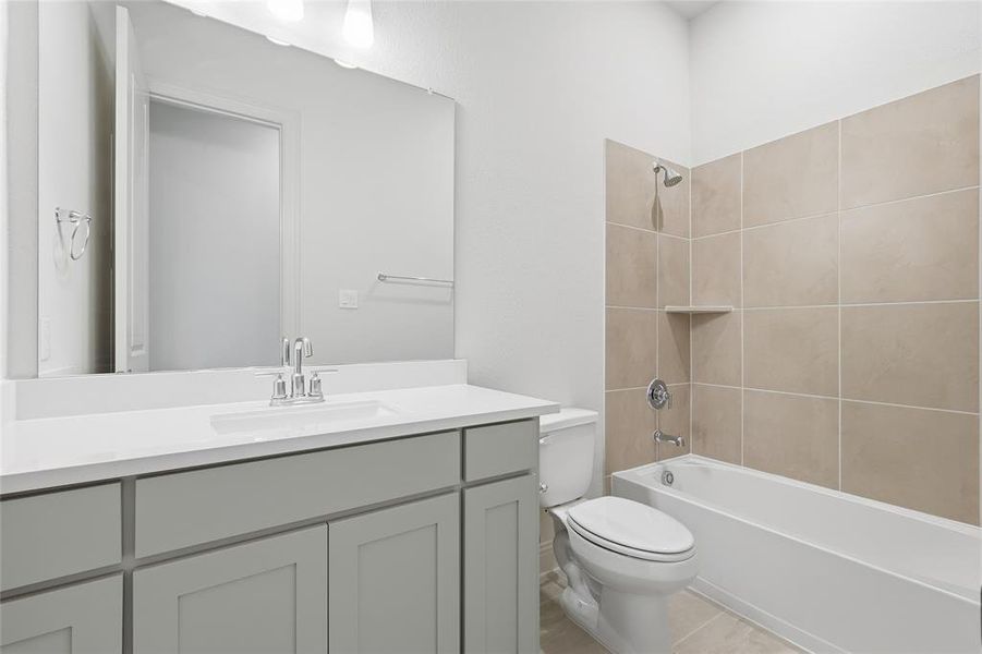 Full bath featuring vanity, shower / bath combination, and light tile patterned flooring