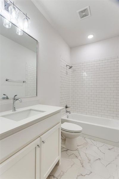 Full bathroom with vanity, toilet, and tiled shower / bath