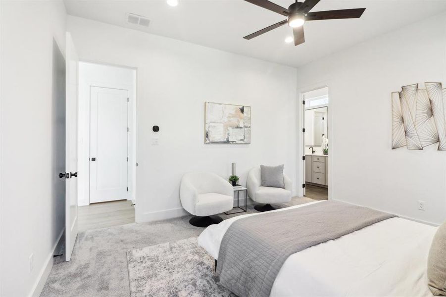 Carpeted bedroom featuring ceiling fan and ensuite bathroom