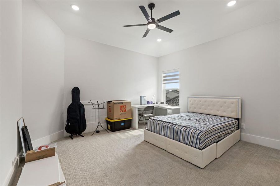Carpeted bedroom featuring recessed lighting and a ceiling fan
