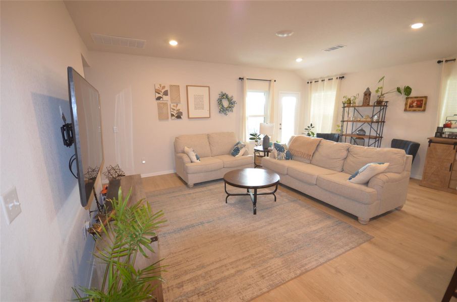 Living area with light wood-style floors and recessed lighting Living area with light wood-style floors and recessed lighting