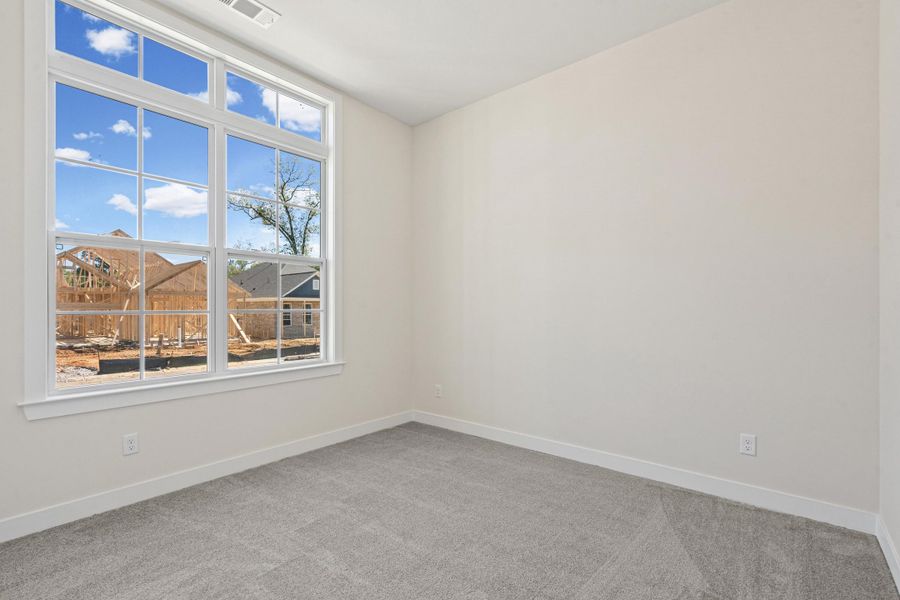 Spare room with light carpet and baseboards