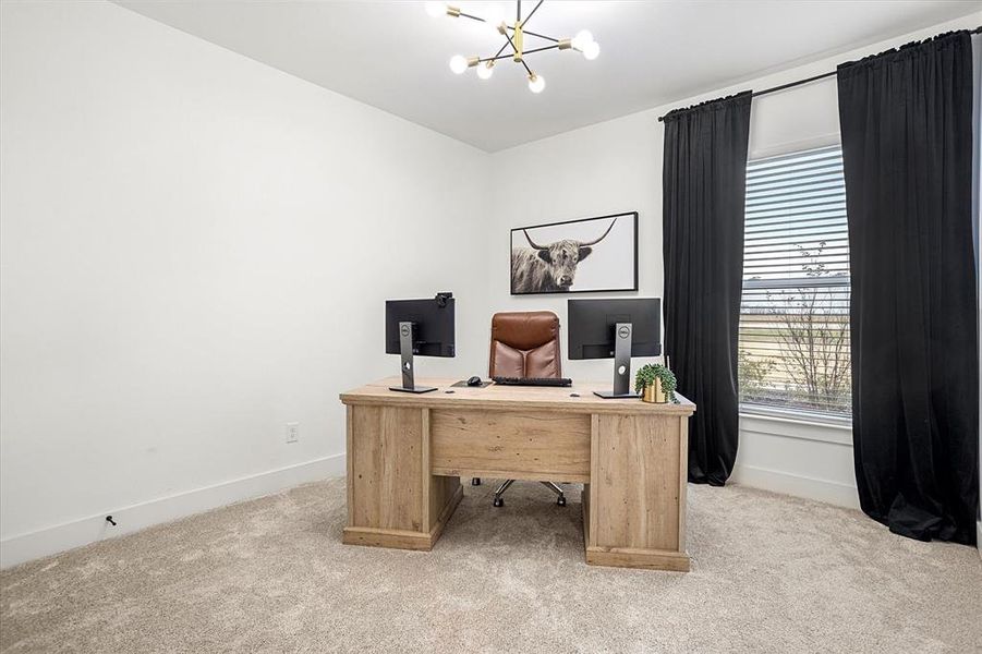 Office area featuring light colored carpet and a notable chandelier