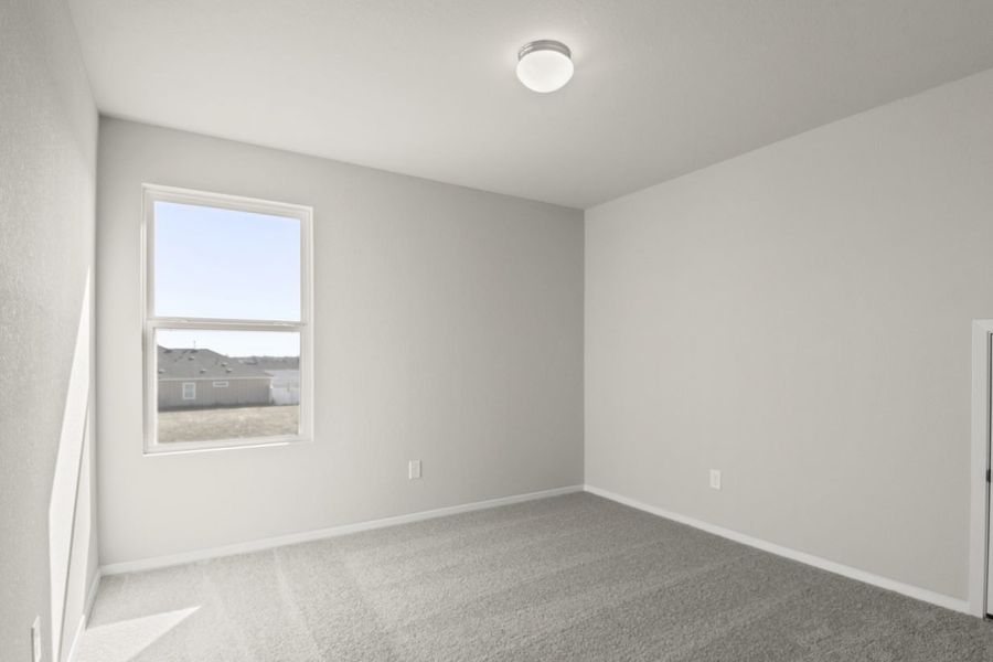Image of a bedroom with cream walls, tan carpeting, a window and white trim