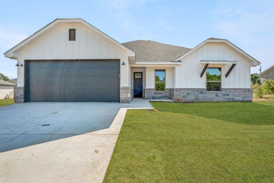 View of front of house with a front lawn and a garage