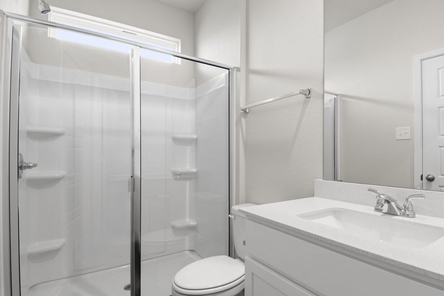 Image of primary bathroom with white cabinets and counter tops with a mirror vanity and a walk in shower