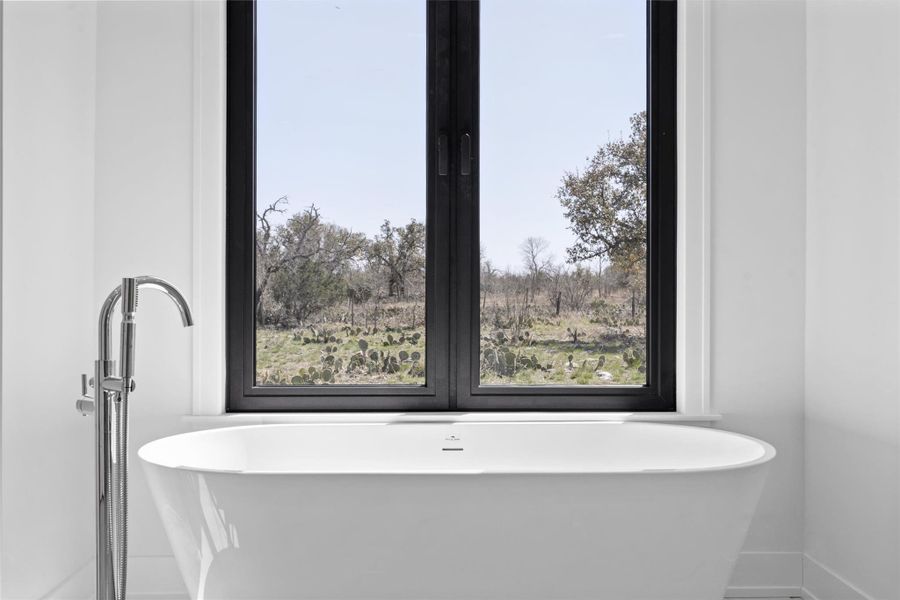 Full bath featuring a freestanding tub and baseboards