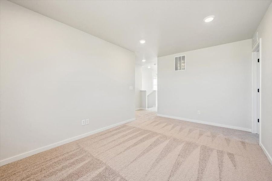 A room with a carpet and a wood floor.