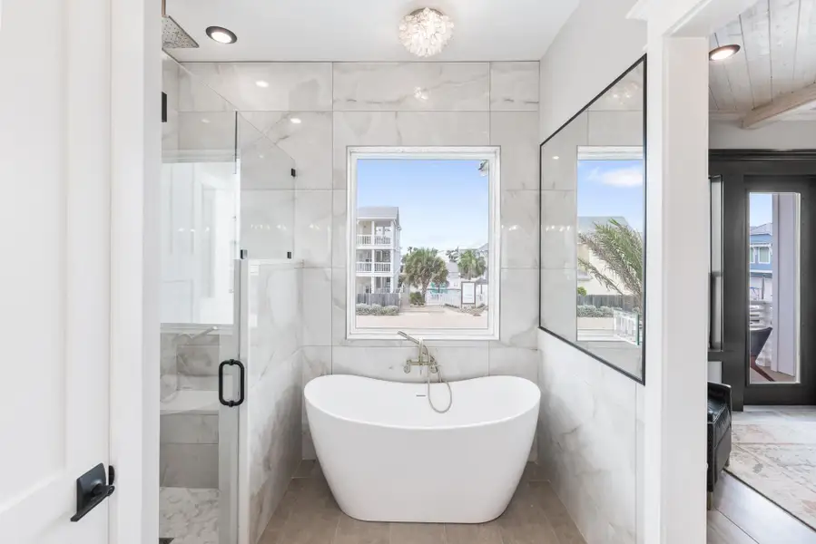 Full bath with a shower stall, a freestanding bath, and tile walls Full bath with a shower stall, a freestanding bath, and tile walls