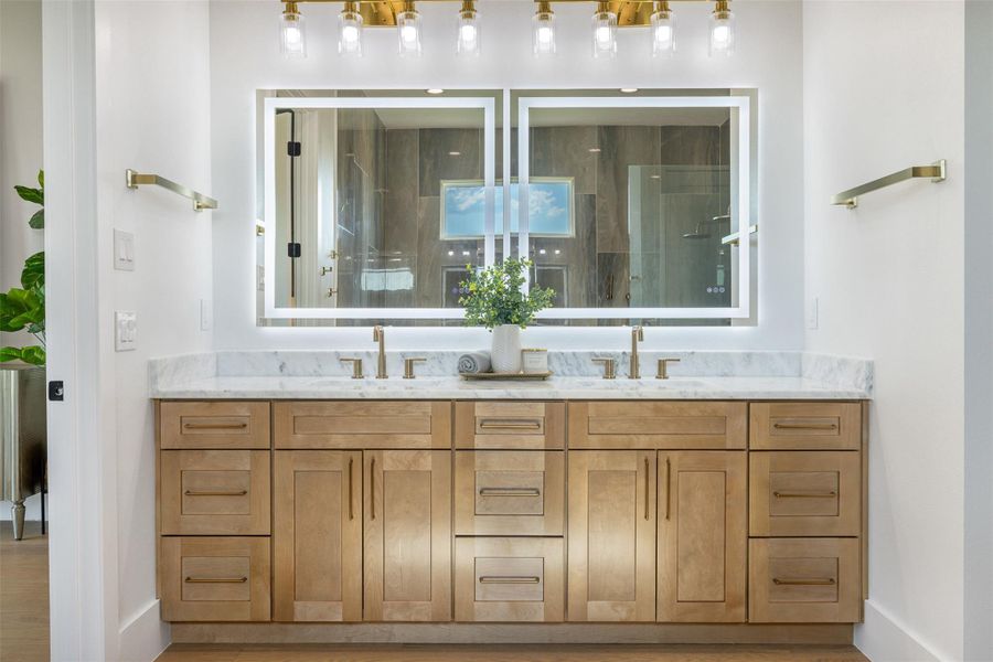 Bathroom featuring a tile shower and double vanity