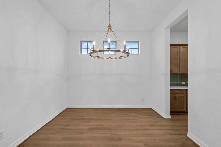 A laid back but refined vibe welcomes you to this formal dining space outfitted with a beautiful gold light fixture.