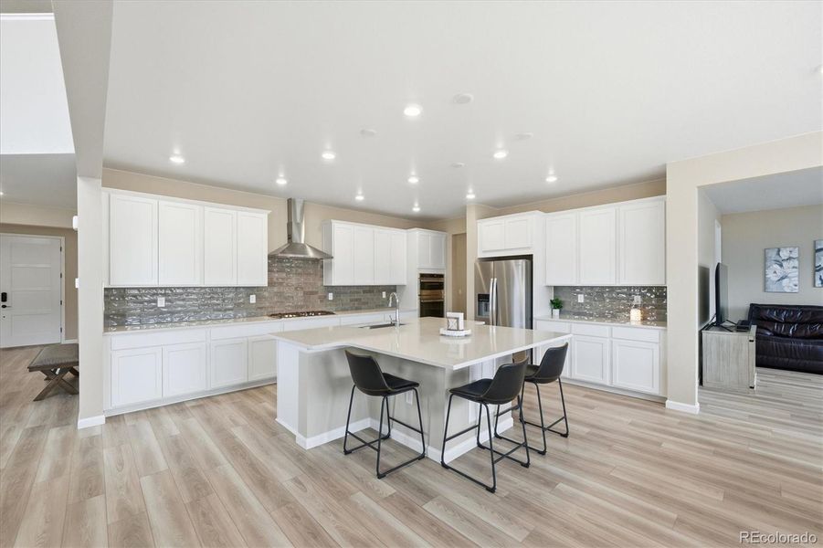 Stunning kitchen with quartz countertops, custom backsplash, oversized island and roll out shelving in all of the lower cabinets.