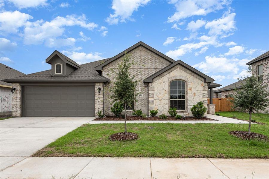 French country home with a garage and a front lawn