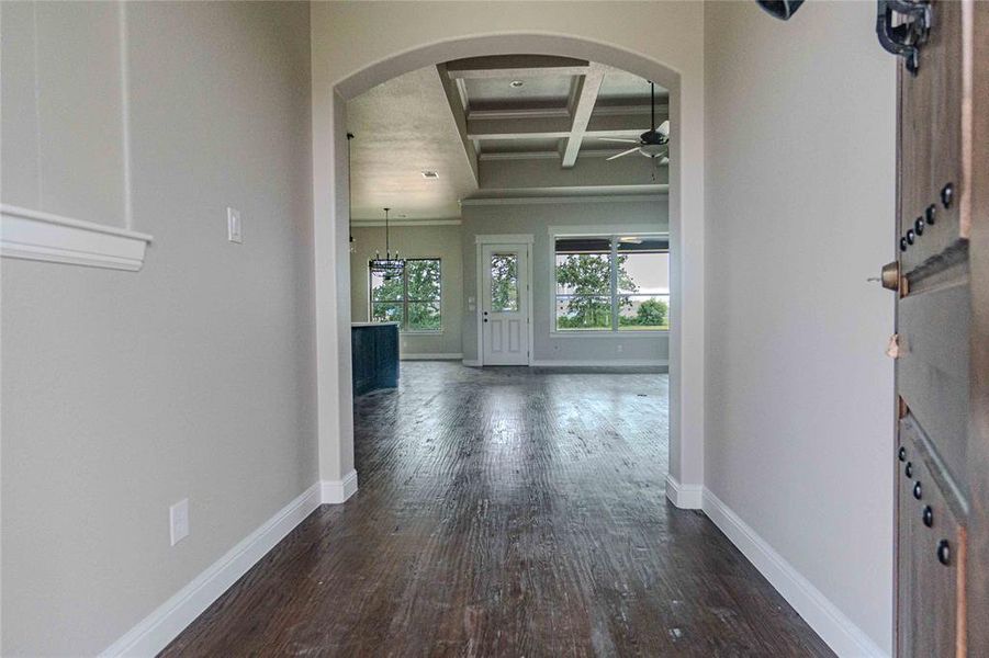 Hallway featuring dark hardwood / wood-style floors, beam ceiling, and coffered ceiling