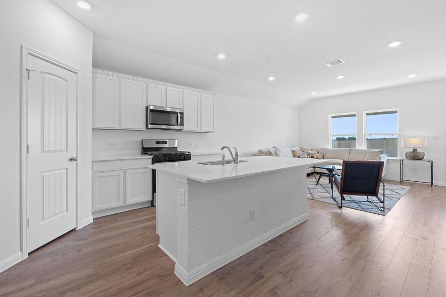 Kitchen with white cabinets, light wood-style floors, recessed lighting, appliances with stainless steel finishes, and a center island with sink Kitchen with white cabinets, light wood-style floors, recessed lighting, appliances with stainless steel finishes, and a center island with sink