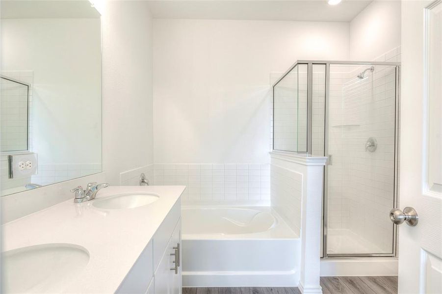Full bath featuring double vanity, dark wood finished floors, a shower stall, and a bath Full bath featuring double vanity, dark wood finished floors, a shower stall, and a bath