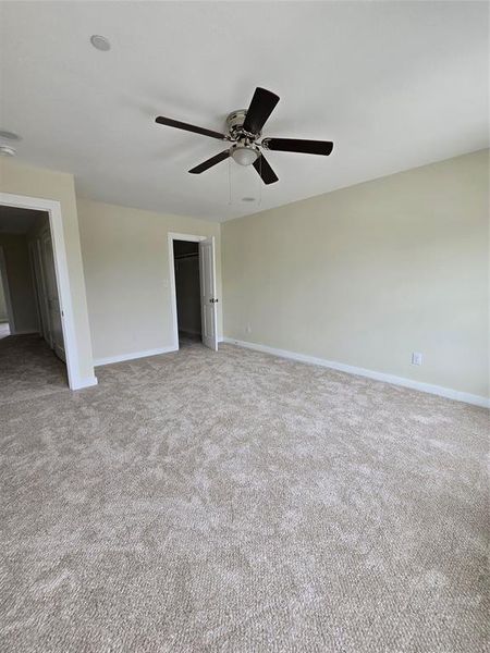 Empty room featuring a ceiling fan, carpet flooring, and baseboards