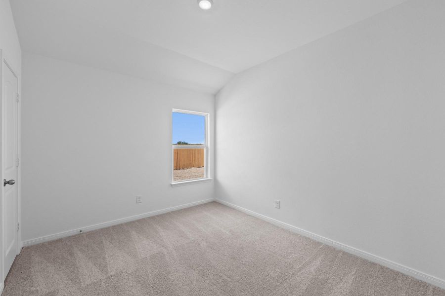 Empty room featuring lofted ceiling and light carpet