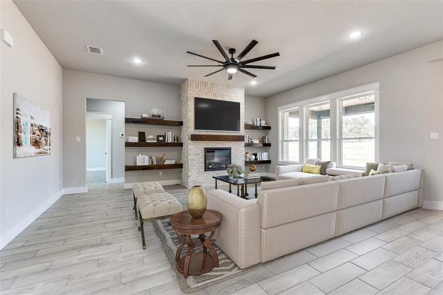 Living room featuring ceiling fan, a fireplace, and light hardwood / wood-style flooring
Virtual Staging