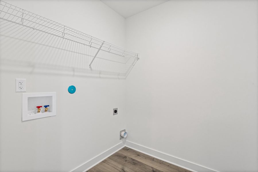 Wire shelving, wood-finish flooring, white walls, and utility hookups