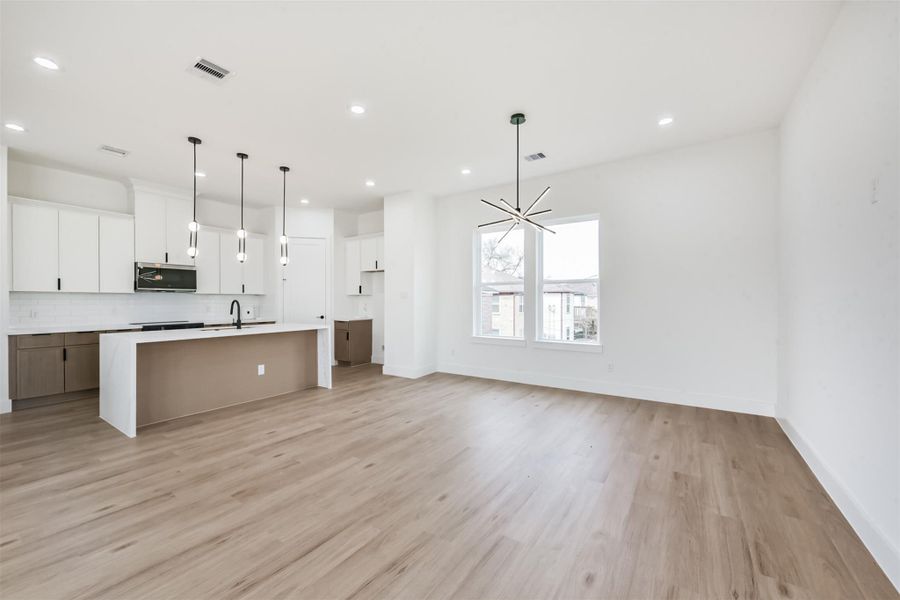 Dining room area with a sleek and modern light fixture. Dining room area with a sleek and modern light fixture.