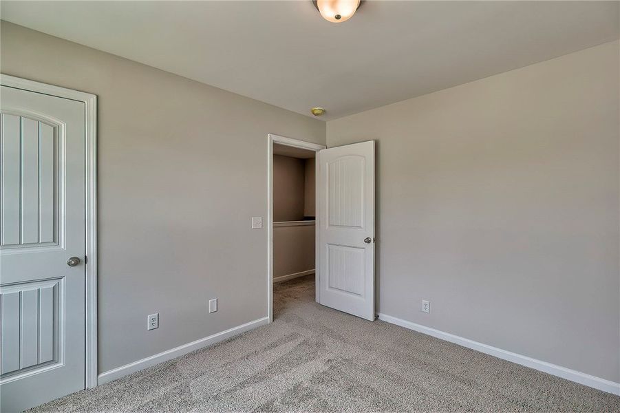 This cozy bedroom features soft carpeting and ampl