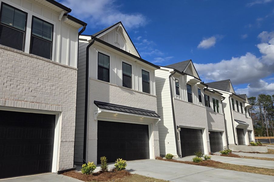 Front exterior of a new home in Azalea Square Townhomes, Lawrenceville, GA, highlighting curb appeal (Image 1).