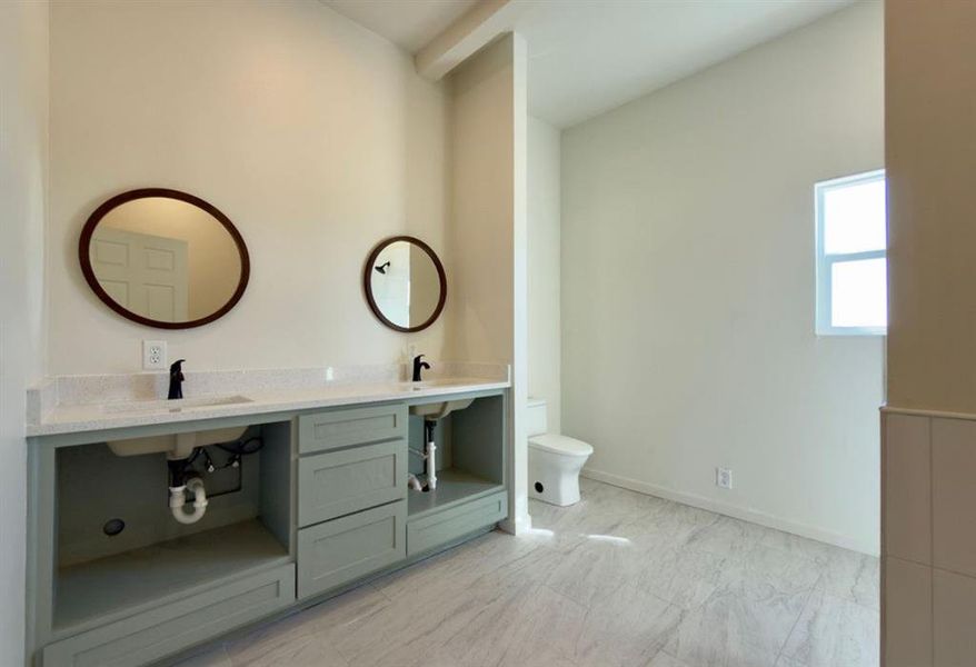 Bathroom featuring double vanity and toilet Bathroom featuring double vanity and toilet
