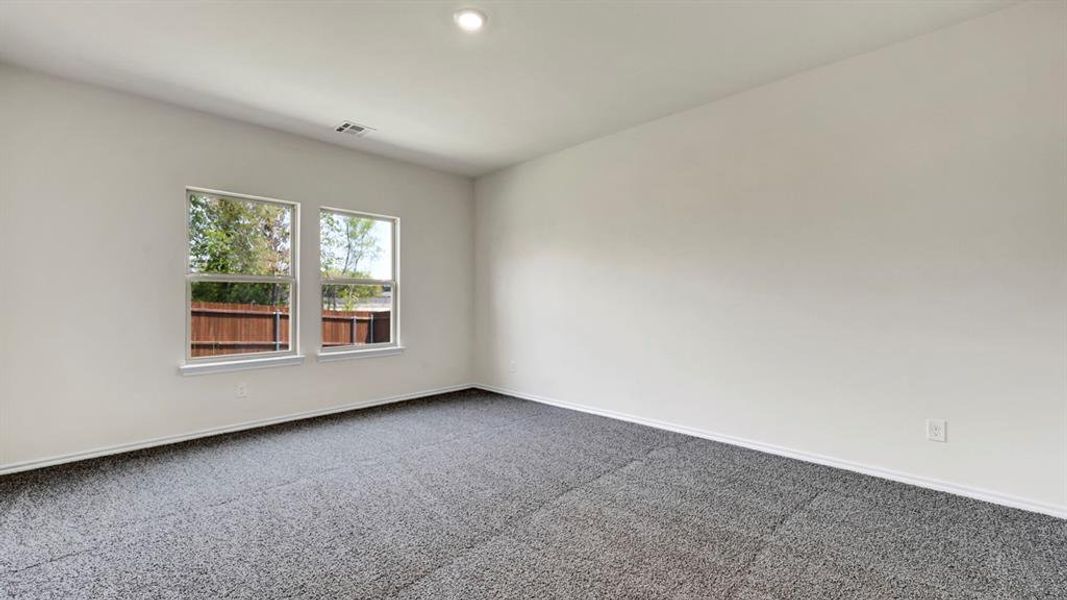 Spacious room featuring neutral carpeting, two large windows, white walls, and a recessed ceiling light
