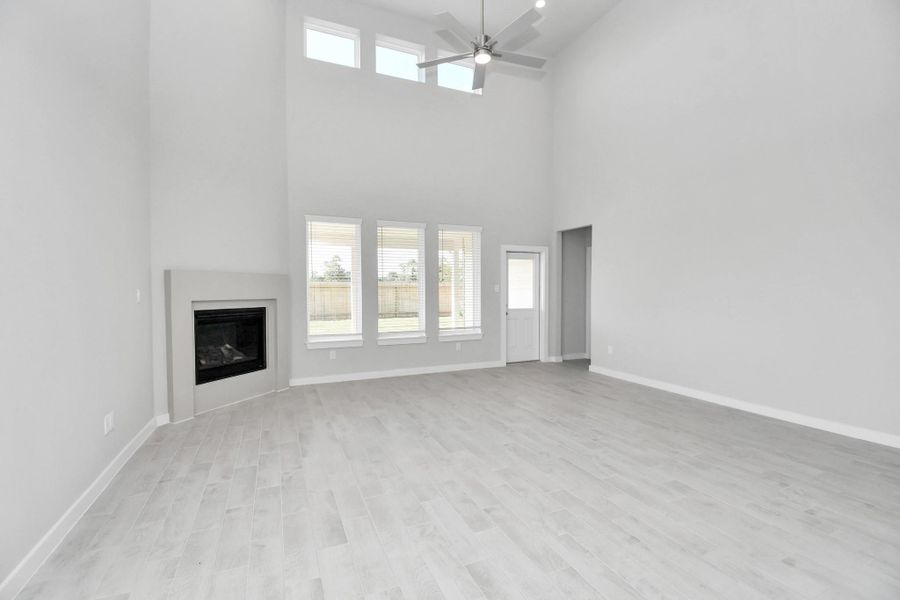Gather the family and guests together in your lovely living room! Featuring soaring high ceilings, recessed lighting, ceiling fan, custom paint, gorgeous floors, and large windows that provide plenty of natural lighting throughout the day. Sample photo of completed home with similar floor plan. Actual colors and selections may vary. Gather the family and guests together in your lovely living room! Featuring soaring high ceilings, recessed lighting, ceiling fan, custom paint, gorgeous floors, and large windows that provide plenty of natural lighting throughout the day. Sample photo of completed home with similar floor plan. Actual colors and selections may vary.