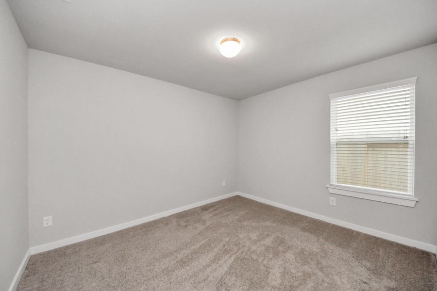 Third bedroom with plush carpeting and a window for natural light, conveniently located near the shared hallway bathroom.