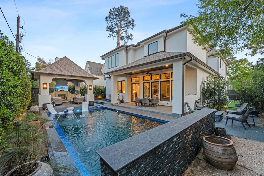 Thoughtfully designed outdoor living space featuring a custom pool, expansive patio, and seamless indoor-outdoor flow. Includes a covered lounge pavilion and multiple areas for entertaining and relaxation.