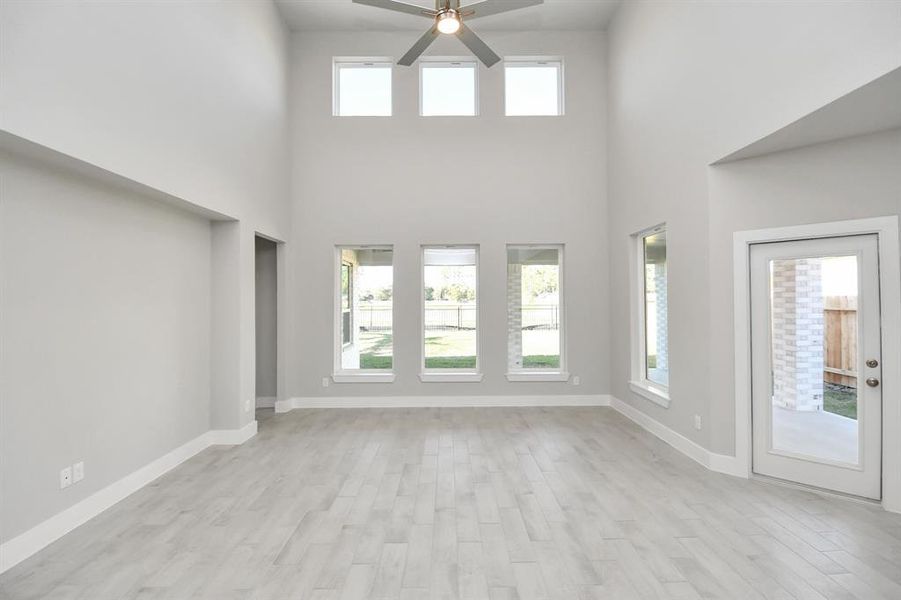 Gather the family and guests together in your lovely living room! Featuring soaring highceilings, recessed lighting, ceiling fan, custom paint, gorgeous floors, and large windows thatprovide plenty of natural lighting throughout the day.