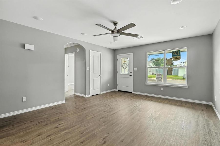 Foyer entrance featuring ceiling fan, wood finished floors, and arched walkways Foyer entrance featuring ceiling fan, wood finished floors, and arched walkways