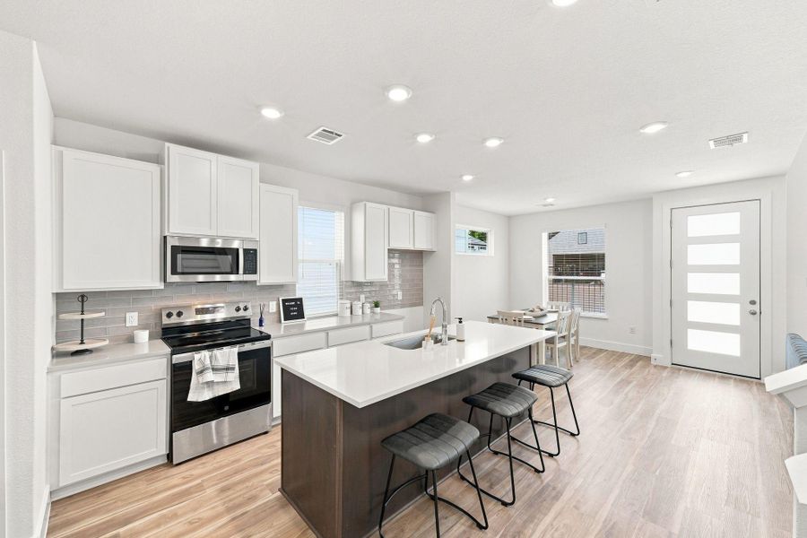 Bright modern kitchen with stainless-steel appliances, large center island, quartz countertops, and an adjoining breakfast area filled with natural light. Bright modern kitchen with stainless-steel appliances, large center island, quartz countertops, and an adjoining breakfast area filled with natural light.