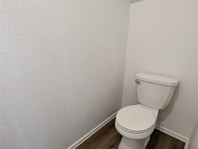 Functional and clean, this restroom features durable wood flooring.