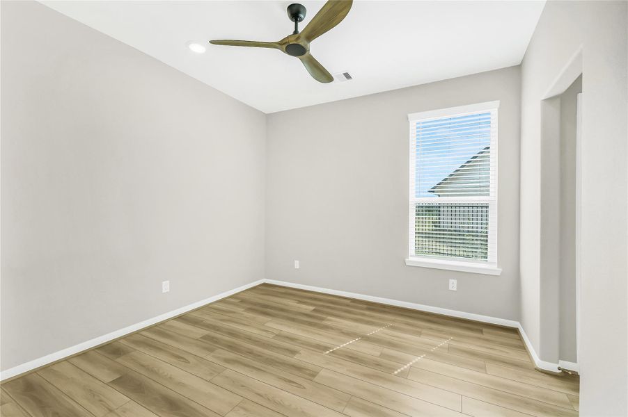 Spacious bedroom offering large windows and plenty of square footage, perfect for a guest room or home office.
